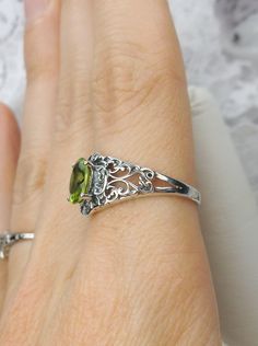 Natural Peridot Ring Description>> Small Nouveau Design#14 MADE TO ORDER Inspired by Victorian and Art Nouveau designs I now offer this stunning Antique reproduction in sterling silver. This gorgeous ring is set with a flawless natural .56ct peridot. The stunning gemstone is 7mm in length by 5mm in width, 3mm depth approximately .56ct Notice the beautifully intricate design of the silver filigree setting and trellis band. Notice the beautiful floral filigree craftsmanship of the setting. T Classic Lime Green Oval Jewelry, Oval Lime Green Ring For Gift, Oval Lime Green Rings For Anniversary, Lime Green Oval Rings For Anniversary, Lime Green Oval Rings With Accent Stones, Oval Lime Green Anniversary Ring, Oval Peridot Rings With Accent Stones, Lime Green Oval Rings Fine Jewelry, Oval Lime Green Fine Jewelry Ring