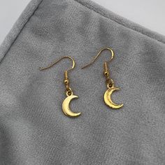 Handmade Gold Moon Dangle Hook Earrings - Cute Hypoallergenic Statement Earrings These earrings are handmade in the UK, all findings and finishings are 925 Sterling or Gold plated 925 Sterling Silver (nickel and lead free) making them all hypoallergenic, perfect for sensitive ears. Each pair is designed and created with care and is backed on one of our Furnessities signature cards and wrapped in tissue paper to ensure safety whilst in transit.  *Designs and colours may vary slightly as each earring pair is handmade and unique* Care instructions: All items are handmade so take care removing from the card and your ears. Not recommended for wear in water. Keep out of the reach of small children as they could be a choking hazard.  Returns: We are unable to accept returns or exchanges of earrin Dainty Half Moon Charm Earrings, Dainty Half Moon Earrings With Moon Charm, Elegant Brass Earrings With Moon Charm, Elegant Hypoallergenic Moon Shaped Earrings, Gold Moon-shaped Earrings With Moon Charm, Minimalist Moon Charm Drop Earrings, Gold Half Moon Handmade Earrings, Dainty Moon Shaped Single Earring, Dainty Single Moon Earring