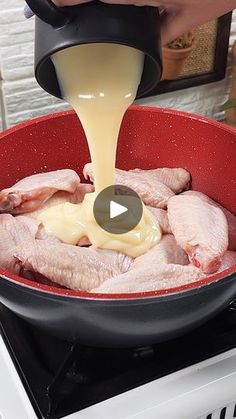 someone pouring sauce on chicken in a red skillet over an electric stove top oven