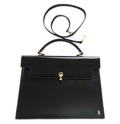 "1990s. Vintage Roberta di Camerino black Kelly bag with golden R logo motif and shoulder strap. Beautiful masterpiece from Roberta back in the era. Introducing a vintage Kelly style leather bag from Roberta di Camerino back in the 90's. If you are a fan or collector then, this is definitely the \"one of a kind piece\" you must get. Featuring a golden tone closure hock and its iconic \"R\" motif at front. With a detachable shoulder strap, you can enjoy carrying as a handbag or on a shoulder. Cle Evening Black Briefcase With Gold-tone Hardware, Classic Formal Bag With Gold Clasp, Classic Formal Bags With Gold Clasp, Formal Leather Bag With Gold Clasp, Vintage Gold Shoulder Bag For Business, Black Kelly, R Logo, Vintage Kelly, Retro Bags