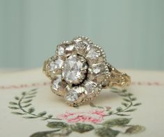 an antique diamond cluster ring sits on a table