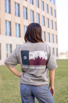 Show off your Aggie pride in this Texas A&M University Silhouette Flag T-Shirt! Made of soft gray fabric, it features the school's name in crisp white font with a purple ATM logo. The back showcases a stunning silhouette of Aggieland in the iconic Texas flag shape. A must-have for any passionate Aggie fan! - Brand: Comfort Wash - 100% Cotton - Machine Wash Cold/Tumble Dry Low Aggie Pride, Texas A M University, Texas Flag, Texas Flags, Concrete Color, Texas A&m, Gray Fabric, Flag Tshirt, Grey Fabric