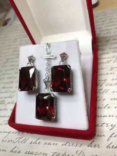 "Earrings & Necklace Set Design#5 Made to Order Red Garnet CZ Earrings (E5) This is a brand new beautiful Art Deco/Edwardian filigree sterling silver pair of red garnet cubic zirconia (CZ) earrings. Each lovely faceted rectangle gemstone is 15mm x 10mm in size each. The earrings are marked 925 for sterling. The earrings are 1\" long with post backs, and approximately 1 and 1/4\" long with hooks. These amazing earrings are pure style and grace. You can dress up or down, it's the perfect state Rectangular Crystal Jewelry For Formal Occasions, Formal Rectangular Crystal Jewelry, Elegant Jewelry With Rectangular Pendant And Matching Earrings, Red Rectangular Sterling Silver Jewelry, Rectangular Red Sterling Silver Jewelry, Crystal Jewelry With Rectangular Stone For Gift, Rectangular Crystal Earrings For Gifts, Silver Rectangular Pendant For Party, Square Gemstone Jewelry For Formal Occasions