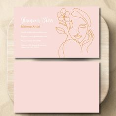 a pink business card with an image of a woman's face and flowers on it