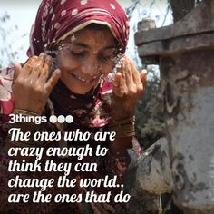 a woman in a red headscarf is drinking water from a faucet