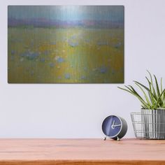 an abstract painting on the wall above a wooden table with a clock and potted plant