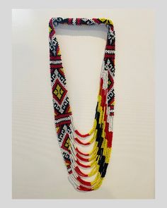 This hand-made T'boli necklace features a layered black, white, red, and yellow bead pattern. This product is made by the T'boli women weavers of Lake Sebu, South Cotabato, Philippines. The T'boli People are known for their colorful ornaments, regal attire, and their unique t'nalak weaving that makes use of abaca and natural dyes. Traditional Handwoven White Beads, Traditional White Handwoven Beads, Traditional Handwoven Black Necklace, Traditional Black Handwoven Necklace, Traditional Handwoven Yellow Beaded Necklaces, Traditional Yellow Handwoven Beaded Necklaces, Traditional Handwoven Yellow Beaded Necklace, Traditional Handwoven Yellow Necklace, Traditional Yellow Handwoven Necklace