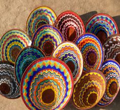 colorful baskets sitting on top of a sandy ground