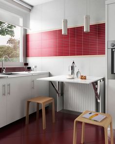 a red and white kitchen with two stools