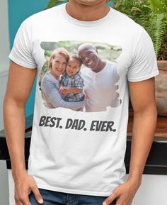 a man wearing a white t - shirt with the words best dad ever printed on it