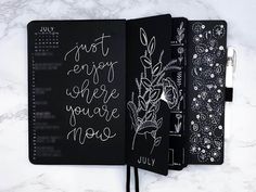 three notebooks with writing on them sitting next to each other and one has a pen in it