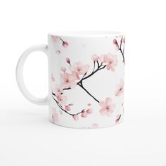 a white coffee mug with pink flowers on the outside and inside, sitting on a white surface