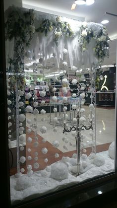 a store window decorated with white flowers and chandeliers