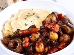 a white bowl filled with mashed potatoes and meat