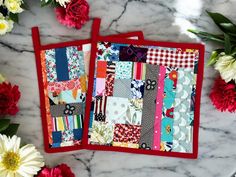 two red placemats sitting on top of a marble counter covered in patchwork