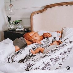 two men laying in bed with their babies