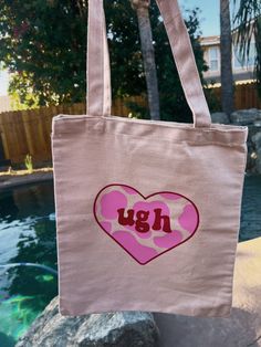 "UGH" Tote bag is out now! *ᴗ* The cow print is in a vibrant bubblegum pink vinyl and the "ugh" letters with outline are red.  I love this canvas tote that holds all things from my laptop, kindle, books, and more. Can be used for shopping, traveling, or carrying books.  Our tote bags are designed to last, with premium materials and precise stitching. The thick, durable fabric and cross-stitching at the handles provide maximum strength to hold up to anything you need to carry. Plus, our 100% natural tote bags are an eco-friendly choice, helping you go green and reduce waste. And if your tote bag gets dirty, no worries! Our machine-washable totes are wrinkle-resistant, so you can easily clean them and keep them looking like new. Features: spacious, versatile, durable, and lightweight.  Size: Casual Pink Shoulder Bag As Gift, Casual Pink Shoulder Bag For Gift, Casual Pink Shoulder Bag Perfect For Gift, Fun Pink Cotton Bag, Fun Pink Shoulder Bag For Shopping, Cute Large Capacity Pink Canvas Bag, Large Capacity Cute Pink Canvas Bag, Cute Pink Large Capacity Canvas Bag, Trendy Pink Canvas Bag As Gift