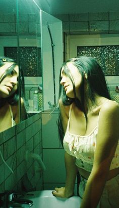 two women are standing in front of a mirror