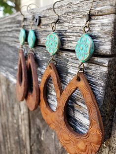 A single, pale turquoise metal bead adds a striking Bohemian pop to these Western teardrop earrings.  Crafted from premium veg-tan leather, these earrings are stamped and dyed by hand making them a truly unique, one-of-a-kind pair. The warm, Caramel Tan really highlights the intricate detailing. This pair also comes in a rich Espresso Brown, and custom color orders are always welcomed.  All my leather earrings start out as blank slates of high quality, veg-tanned leather. Each set is sealed and Tan Leather Earrings, Wooden Teardrop Earrings Diy, Leather Earrings Western, Leather Teardrop Earrings, Leather Painted Earrings, Hand Tooled Teardrop Bohemian Earrings, Bohemian Hand Tooled Teardrop Earrings, Bohemian Teardrop Hand Tooled Earrings, Bohemian Turquoise Hand-tooled Earrings