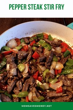 a pan filled with meat and vegetables on top of a wooden table