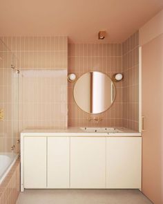 a bathroom with two sinks, a mirror and a bathtub in the middle of it