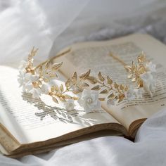 an open book with a tiara on top of it sitting on a white bed