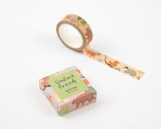 a roll of washi tape sitting next to a box with an animal print on it