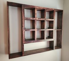 a wooden shelf with several open shelves on it's sides and one section missing from the wall