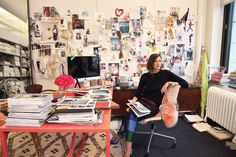 a woman sitting at a desk with papers on it