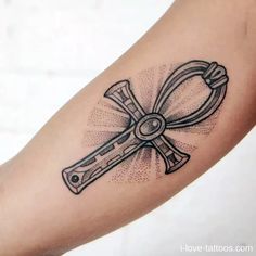 a tattoo on the arm of a person with a cross and wrench in it