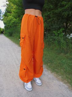 These bright orange cargo/parachute pants are the coolest Fall and Winter wardrobe staple. Featuring 4 pockets, an adjustable drawstring cord waistline, and adjustable cord drawstring ankles. Emily is wearing size S. Petal Pants, Cargo Parachute Pants, Parachute Pant, Crochet Mini Dress, Bathing Suit Top, Halter Mini Dress, Cargo Pant, Pink Mini Dresses, Bright Orange