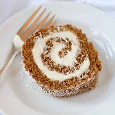 a white plate topped with a piece of cake next to a fork