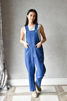 JUNE linen dungarees are a loose style jumpsuit with a comfortable fit through the waist and hips. The model has classic details and a lot of pockets. The cropped pants design makes these harem linen overalls modern and cozy to wear. ▶ FIT JUNE linen jumpsuit is of relaxed fit allowing you to wear it with a top underneath. The straps are finished with wooden buttons. We recommend choosing your usual size to have a fit like the one shown on the model. ▸ The model is wearing size XS, color Sea Blu Sleeveless Denim Jumpsuit With Relaxed Fit And Pockets, Sleeveless Denim Jumpsuit With Pockets And Relaxed Fit, Relaxed Fit Full Length Jumpsuits And Rompers With Pockets, Full Length Relaxed Fit Jumpsuits And Rompers With Pockets, Sleeveless Relaxed Fit Shortalls With Pockets, Casual Sleeveless Jumpsuits And Rompers With Pockets, Casual Full Length Relaxed Fit Overalls, Casual Sleeveless Jumpsuits With Slip Pockets, Casual Sleeveless Overalls With Side Pockets