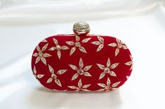 Red Clutch Designer made for Weddings w/ Minimal Zardozi Minimal clutch adorned with simple floral zardozi, bead & sequin embellishments. This red clutch purse evening -wear with a stone-studded closure at the top is a must-have in your wardrobe - a versatile accessory for any party outfit!  Lining: Fabric Color: Red Embroidery: Zardozi, Sequin & Bead Size & Dimensions:  Height - 5 in Width - 8 in Depth - 1.5 in Fits most of the phones. Strap: Detachable shoulder metal chain strap  Closure: Comp Elegant Hand Embellished Evening Bag For Events, Elegant Hand Embellished Party Bags, Handmade Glamorous Evening Bag For Wedding, Red Festive Evening Bag, Red Embellished Evening Bag, Glamorous Hand Embellished Clutch Evening Bag, Glamorous Hand Embellished Evening Bag For Formal Events, Festive Red Embroidered Evening Bag, Festive Red Evening Bag