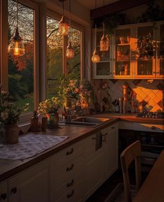 a kitchen filled with lots of counter top space next to a window covered in hanging lights