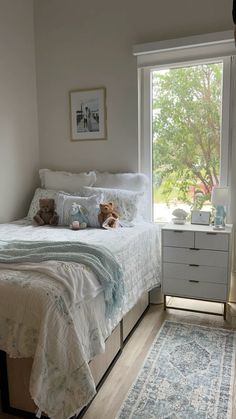 a bed room with a neatly made bed next to a window and a rug on the floor