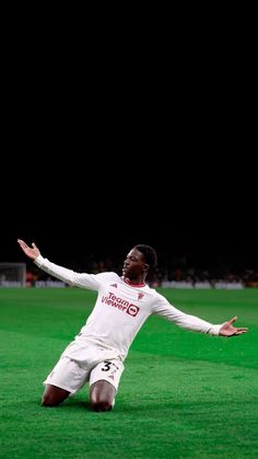 a soccer player sitting on the ground with his arms spread out in front of him