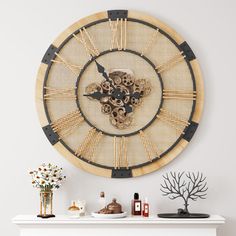 a wall clock made out of bamboo and metal with an intricate design on the face