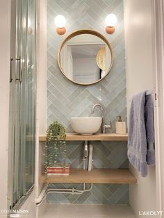 a bathroom with a sink, mirror and shower stall in the corner next to it