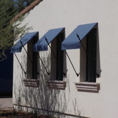 three blue awnings on the side of a white building