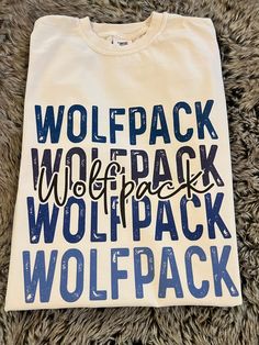 Get this popular new Wolfpack stacked text shirt and show off your school spirit in style!  Each shirt is printed in-house by me using high-quality materials on a Comfort Colors shirt, known for its exceptional comfort, style, and durability. Available in unisex sizes S to 3X, and youth sizes, we've got you covered regardless of your preferred fit. The Bulldogs stacked text Shirt features a classic crew neck and short sleeves, making it suitable for year-round wear. The flattering silhouette ens School Spirit Shirt With Letter Print For Game Day, School Spirit Cotton Shirt With Text Print, Cotton School Spirit Shirt With Text Print, Blue Graphic Print T-shirt For Back To School, School Spirit T-shirt With Lettering For Fans, School Spirit Cotton Shirt With Letter Print, Cotton School Spirit Shirt With Letter Print, Fan Merchandise T-shirt With School Spirit Lettering, White T-shirt With Text Print For College Events