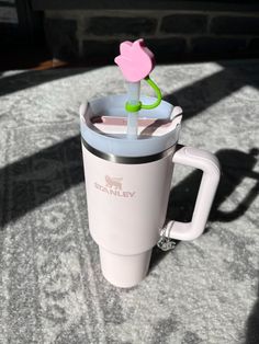 a coffee cup with a flower sticking out of it's side on a table