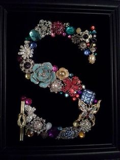 the letter s is made up of many different types of beads and brooches