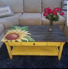 a coffee table painted with sunflowers and red roses in a living room setting