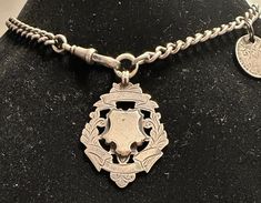 "An early 1900s English sterling curbed Albert watch chain with decorative engraved fob or tag plus a silver 1915 silver coin,  The condition is very good chain and fob have English Lion passant stamps, tag is signed by HB & S.  Length approx. 14.5\", fob-approx 1 1/2\" by 1 3/16\", wt.- 41.6 grams.The curb link chain is graduated from 5mm to 9.5mm in width. Rapped twice around wrist interesting charm bracelet.  Nice antique design and quality." Silver Medallion Necklace With Curb Chain, Historical Silver Medallion Jewelry, Victorian Silver Curb Chain Jewelry, Victorian Silver Jewelry With Curb Chain, Vintage Silver Curb Chain Jewelry, Vintage Silver Jewelry With Curb Chain, Pyrope Garnet, Long Drop Earrings, Diamond Charm