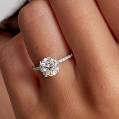 a woman's hand holding an engagement ring with a diamond in the shant