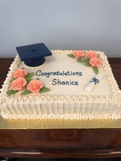 a cake decorated with flowers and a graduation cap on top that says congratulations shanice