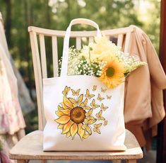 "Purchases made by December 9th are expected to arrive at their destinations before Christmas; however, this is not a guarantee.  Orders placed after this date will still be accepted and processed as soon as possible, but may not arrive before Christmas Day.   Discover the enchantment of nature with our Fluttering Sunflower Canvas Tote Bag! This magical tote depicts a sunflower in radiant bloom, releasing a cascade of delicate butterflies, symbolizing transformation, light, and the untamed beauty of the natural world. 🦋 This 100% cotton bag comes in one size - 15\" x 16\"- perfect for everyday wear. The bag features 20\" handles (made from the same canvas), making it easy to carry even with a week's worth of shopping. .: 100% cotton canvas .: Heavy fabric (12 oz/yd² (406.9 g/m .: Sewn-in Everyday Sunflower Design Tote Bag, Everyday Sunflower Tote Bag, Bohemian Flower-shaped Bag For Gifts, Yellow Sunflower Design Bags For Daily Use, Yellow Canvas Bag As Gift, Origami Tote Bag, Personality Gifts, Funny Coffee Shirts, Sunflower Canvas