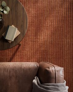 a table with a book and some books on it next to a brown leather couch