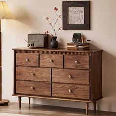 a wooden dresser sitting next to a lamp in a room